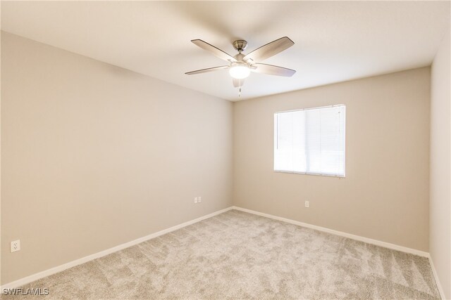 empty room featuring ceiling fan and light colored carpet