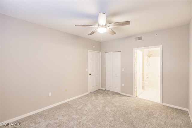 unfurnished bedroom featuring light carpet, ensuite bath, and ceiling fan