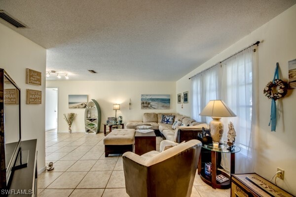 tiled living room featuring a textured ceiling