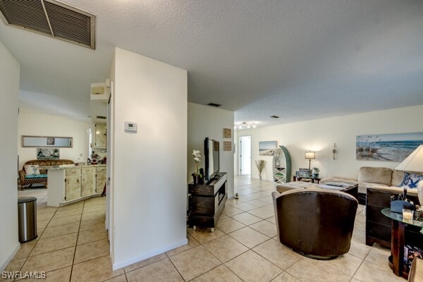 tiled living room featuring a textured ceiling