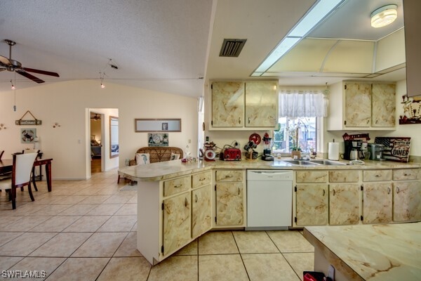 kitchen with ceiling fan, kitchen peninsula, white dishwasher, lofted ceiling, and light tile patterned flooring