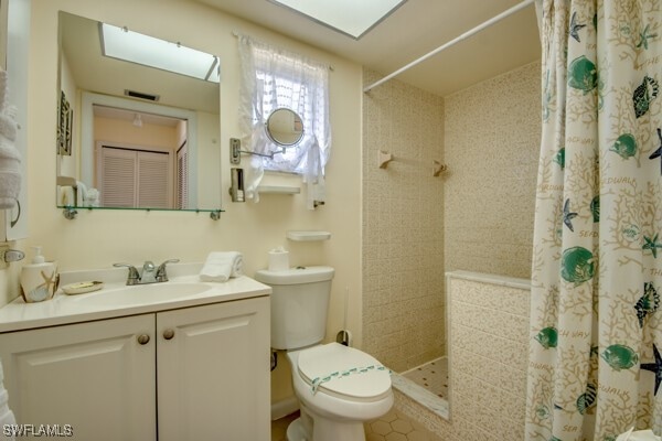 bathroom with a shower with shower curtain, vanity, and toilet