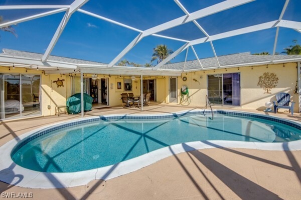 view of pool with ceiling fan, a lanai, and a patio