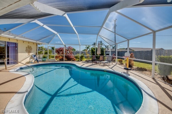 view of pool with a patio and glass enclosure