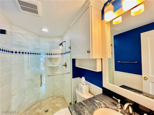 bathroom with walk in shower, vanity, and toilet