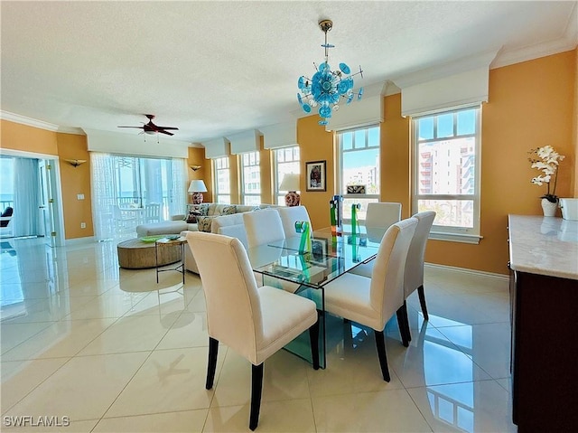 tiled dining space featuring crown molding, ceiling fan, and a textured ceiling