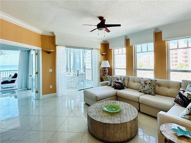 tiled living room featuring a textured ceiling, ceiling fan, and crown molding