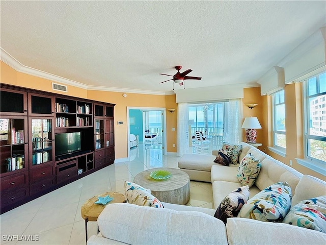 living room with ceiling fan, light tile patterned flooring, a textured ceiling, and ornamental molding