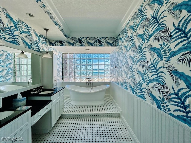 bathroom featuring vanity, a bathtub, and a textured ceiling