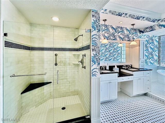 bathroom with shower with separate bathtub, vanity, and a textured ceiling