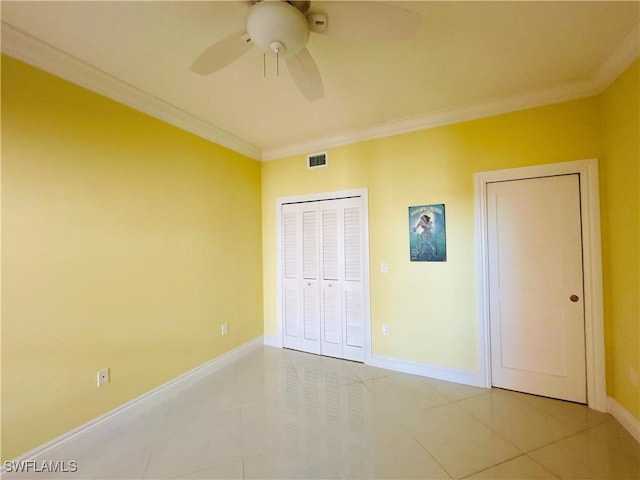 unfurnished bedroom with tile patterned flooring, ceiling fan, ornamental molding, and a closet