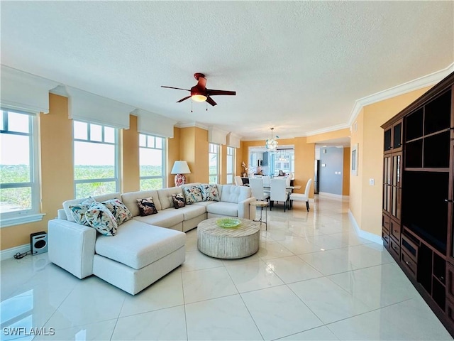 living room featuring ceiling fan, light tile patterned floors, ornamental molding, and a textured ceiling