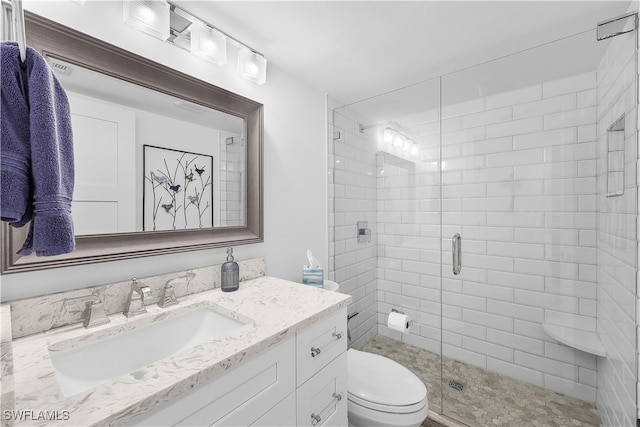 bathroom with vanity, a shower with shower door, and toilet