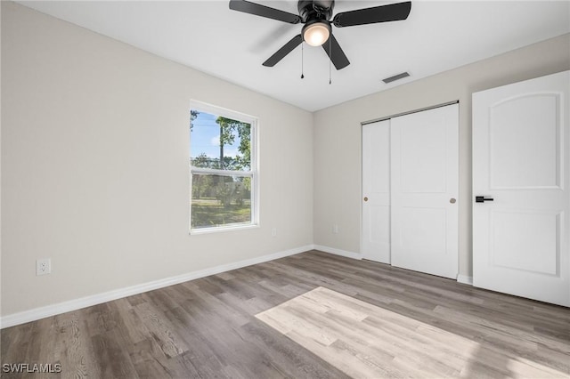 unfurnished bedroom featuring a closet, light hardwood / wood-style flooring, and ceiling fan