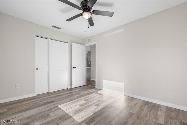 unfurnished bedroom featuring a closet, light hardwood / wood-style flooring, and ceiling fan