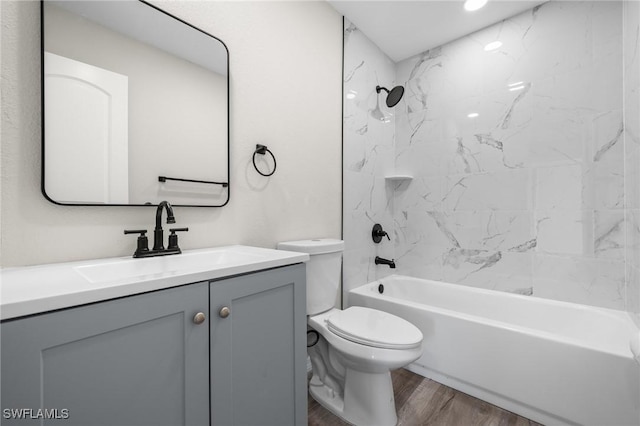 full bathroom with hardwood / wood-style floors, vanity, toilet, and tiled shower / bath