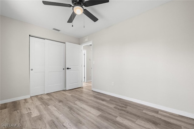 unfurnished bedroom featuring a closet, light hardwood / wood-style floors, and ceiling fan