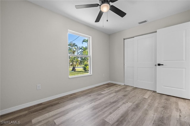 unfurnished bedroom with ceiling fan, a closet, and light wood-type flooring