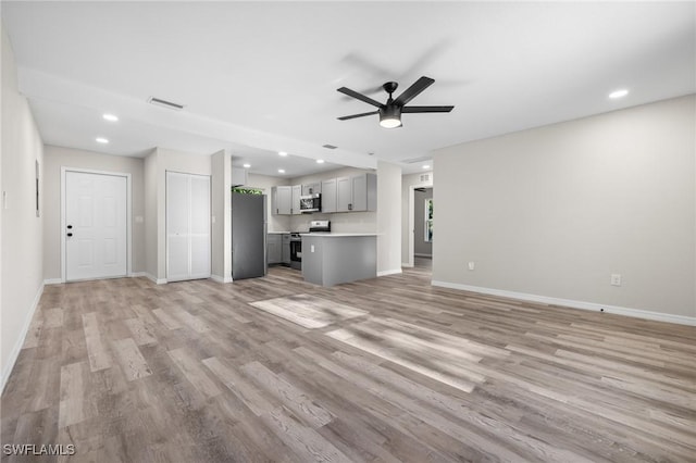 unfurnished living room with ceiling fan and light hardwood / wood-style flooring