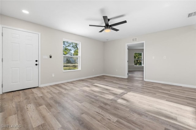 empty room with light hardwood / wood-style floors, ceiling fan, and a healthy amount of sunlight