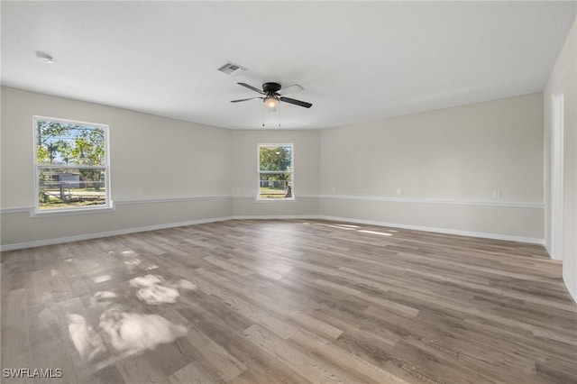 empty room with ceiling fan and light hardwood / wood-style flooring