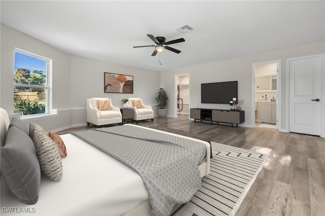 bedroom with hardwood / wood-style floors, ensuite bath, and ceiling fan