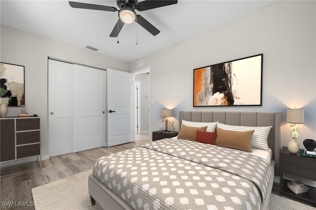 bedroom with wood-type flooring, a closet, and ceiling fan