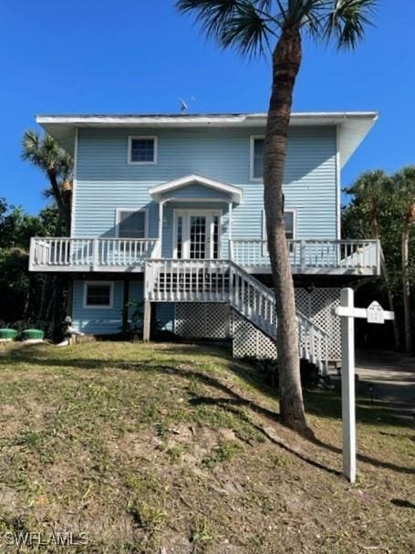 rear view of property with a yard and a wooden deck