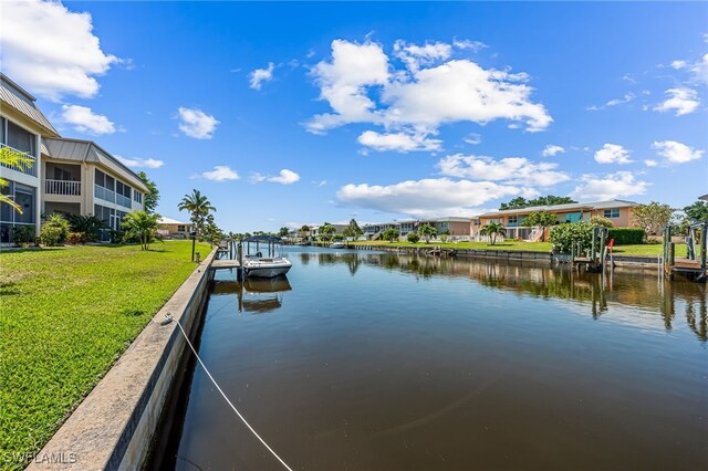 dock area featuring a water view and a lawn