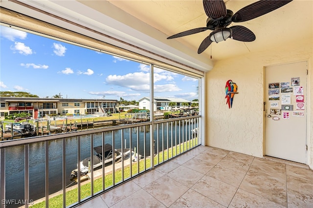 balcony with ceiling fan and a water view