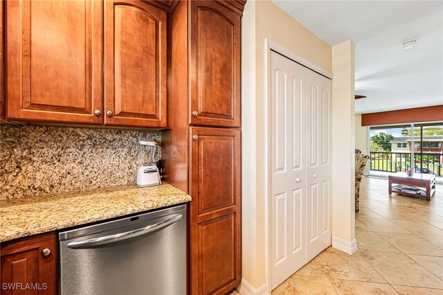 kitchen featuring light stone counters, light tile patterned floors, tasteful backsplash, and dishwasher