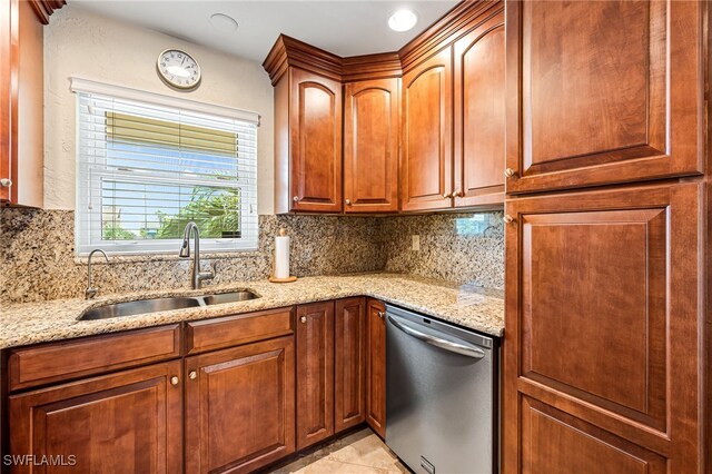 kitchen featuring tasteful backsplash, sink, stainless steel dishwasher, and light stone counters