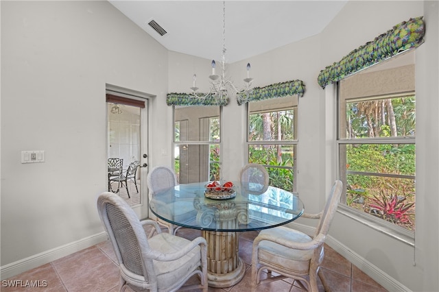 tiled dining room with a wealth of natural light, a chandelier, and lofted ceiling