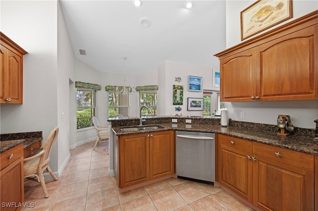 kitchen featuring kitchen peninsula, stainless steel dishwasher, sink, dark stone countertops, and light tile patterned flooring