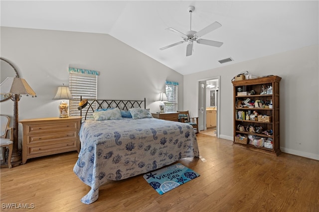 bedroom featuring ceiling fan, light hardwood / wood-style floors, lofted ceiling, and ensuite bath