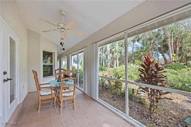 sunroom / solarium with ceiling fan and vaulted ceiling