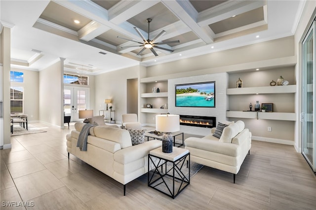 living room with french doors, a large fireplace, crown molding, and built in features