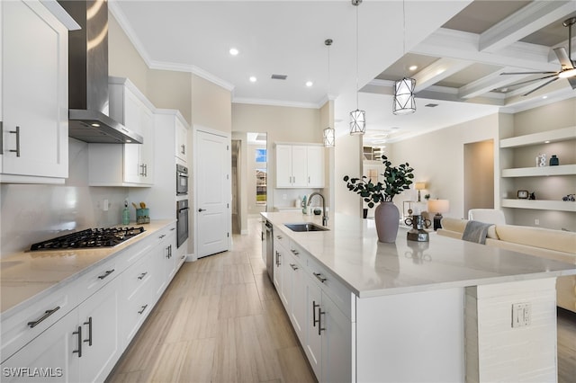 kitchen featuring a large island, wall chimney range hood, sink, and white cabinets