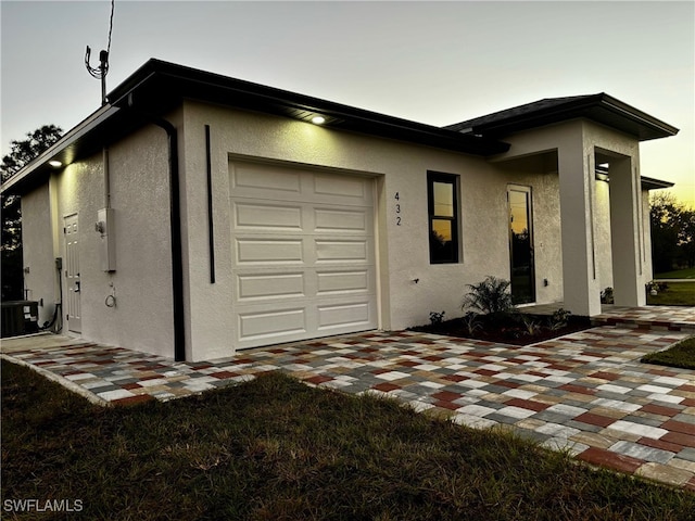 view of front facade featuring central AC unit and a garage