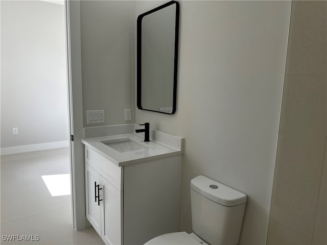 bathroom with tile patterned flooring, vanity, and toilet