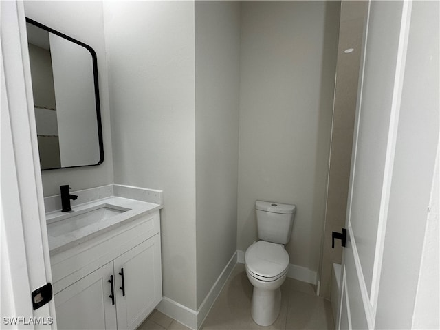 bathroom featuring tile patterned flooring, vanity, and toilet