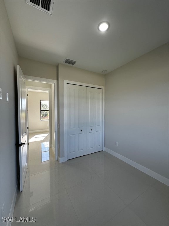 unfurnished bedroom featuring light tile patterned floors and a closet