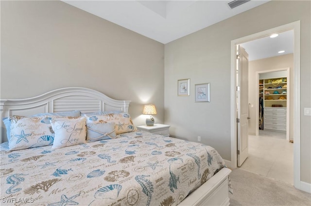 carpeted bedroom with a walk in closet and a closet