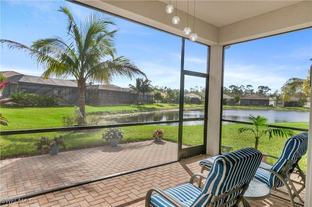 sunroom featuring a water view