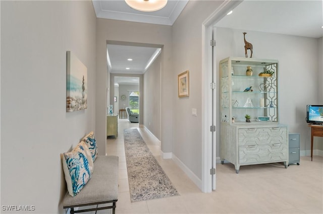 hall with light tile patterned flooring and crown molding