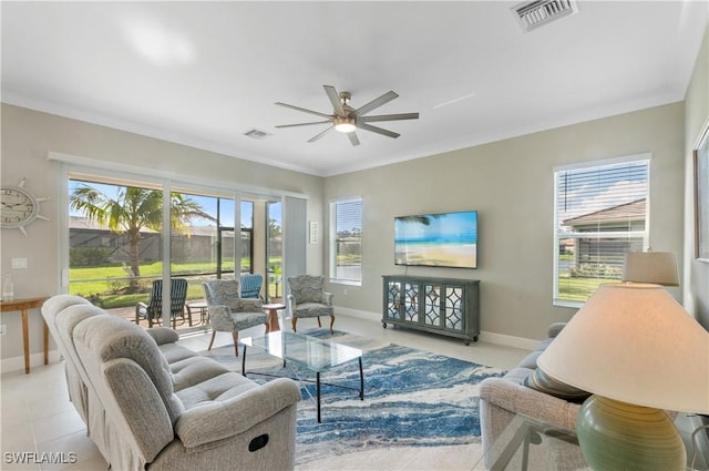 tiled living room featuring ceiling fan, plenty of natural light, and ornamental molding