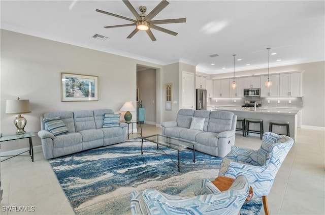 living room with ceiling fan, crown molding, and light tile patterned floors