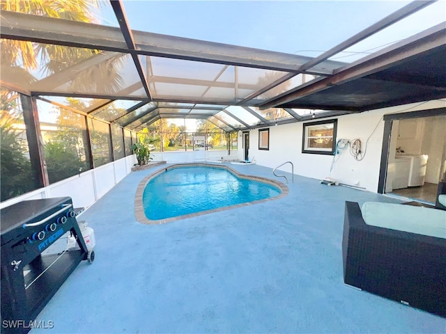 view of swimming pool featuring washer / dryer, a patio, and a lanai