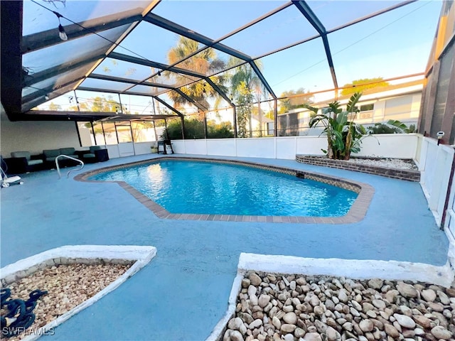 view of swimming pool with glass enclosure, a patio area, and an outdoor hangout area