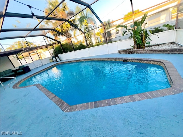 view of swimming pool featuring glass enclosure